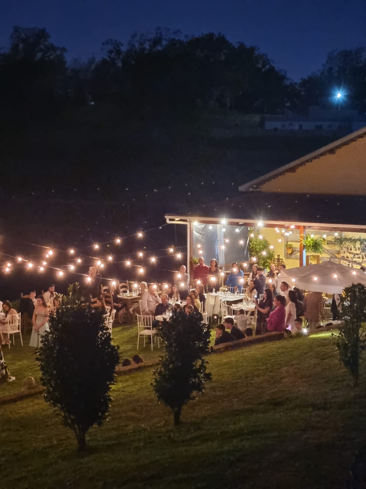 Casamento à noite no Beer Garden com varal de luzes sobre as mesas